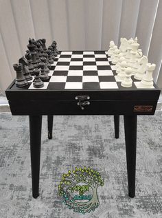 the chess board is made out of black and white pieces, which are sitting on top of a table