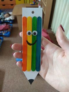 a person holding up a pencil shaped like a smiling face