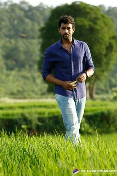 a man standing in the middle of a lush green field