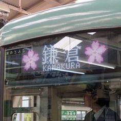 a man standing on the side of a bus looking at it's display window