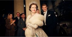 a woman wearing a tiara standing next to a man in a tuxedo