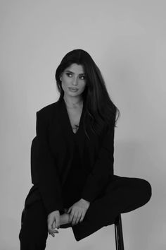 a black and white photo of a woman sitting on a chair