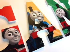 three thomas the tank engine magnets are hanging on a wall in a children's room