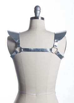 This chestpiece shoulder harness adds drama and impact to any outfit. Epaulette shoulder "wing" details. Show them you mean business! This piece works especially well with dresses and flowing tops that don't have a defined waistline. Silver toned nickel-plated steel hardware. Shown in silver metallic leather (silver leather is now lined and stitched!). Also available in black leather, black vegan leather, and PVC.Buckles in front across chest. All pieces are MADE TO ORDER, standard sizes XS-4XL. Shoulder Harness, Gothic Accessories, Black Vegan, Natural Tan, Leather Silver, Metallic Leather, Custom Fit, Tan Leather, Metallic Silver