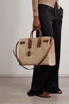 An understated addition to your collection of basket bags, SAINT LAURENT's raffia 'Sac de Jour' tote is free from logos - though you're likely to recognize the padlock and tabs from leather styles of the same name. The silhouette is slouchy with accordion sides that expand to fit beach essentials. The leather-trimmed canvas pouch can be removed and used alone. Designer Natural Straw Bag For Daily Use, Designer Natural Woven Straw Bag, Designer Natural Basket-shaped Bags, Luxury Straw Bag With Woven Leather Basket, Designer Rectangular Straw Bag In Natural Color, Designer Straw Basket Bag With Braided Handles, Designer Rectangular Natural Straw Bag, Designer Handwoven Rectangular Straw Bag, Designer Straw Bags With Intrecciato Weave