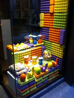 a display case filled with lots of different colored legos and cups on top of each other