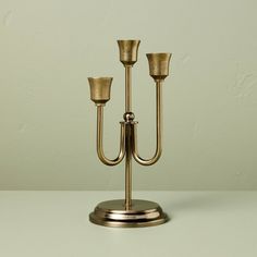 two brass candelabra candlesticks on a white table