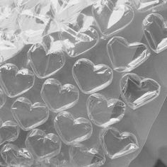 many clear plastic hearts are stacked on top of each other