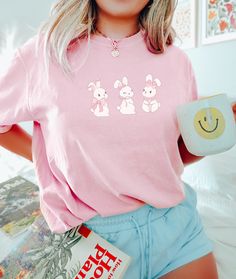 Coquette Bow Easter Bunny t-shirt. These tees are Comfort Colors and are made to last using premium ringspun cotton, this creates an vintage-soft shirt. The soft-washed, garment-dyed fabric brings extra coziness to your wardrobe while the relaxed fit makes it an excellent daily choice. ✦ 100% Ringspun Cotton ✦ Relaxed fit ✦ Medium fabric ✦ Sewn-in twill label ✦ Eco-friendly, Ethically Made & Sweatshop Free ✦ Printed to order with non-toxic ink ✦ Durable and Long-lasting ✦ Shirts are pre-shrunk b Cute Cartoon Print Crew Neck T-shirt, Cute Cartoon Print Tops, Cute Crew Neck Tops For Spring, Cute Crew Neck T-shirt, Spring Cartoon Print Relaxed Fit Shirt, Spring Casual Shirt With Cartoon Print, Kawaii Crew Neck Summer Tops, Kawaii Crew Neck Top With Letter Print, Spring Kawaii Letter Print Tops