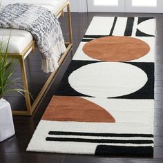 an area rug with various shapes and colors on the floor next to a bench in a room