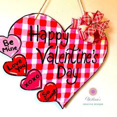 a valentine's day sign hanging on a wall with two hearts attached to it