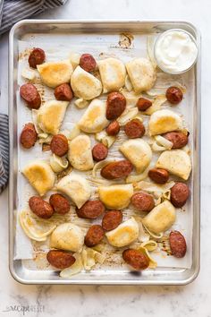 a baking sheet filled with sausage and pasta