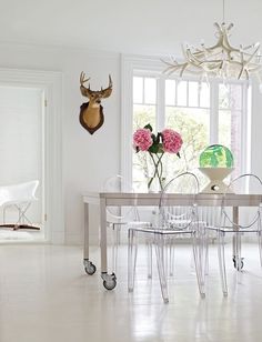 a dining room table with chairs and vases on it