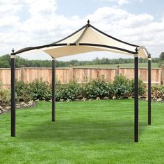 a white and black gazebo sitting on top of a lush green field