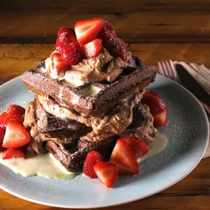 a stack of waffles topped with ice cream and strawberries on a plate