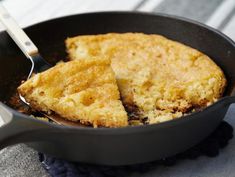 a skillet with some food in it on a table next to a fork and napkin