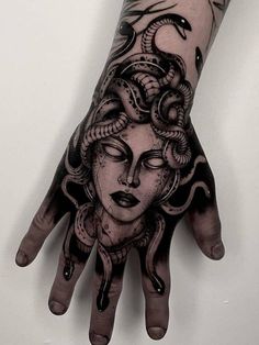 a woman's hand with a tattoo on it and a snake around her wrist