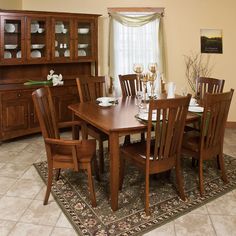 a dining room table with chairs and a china cabinet