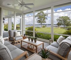 a living room filled with furniture next to a large window covered in lots of windows