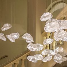 a chandelier hanging from the side of a staircase with clear glass pieces suspended from it