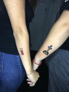 two people are holding hands with tattoos on their arms and one has a small airplane