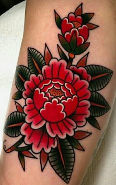 a red flower with green leaves is on the arm and it's petals are blooming