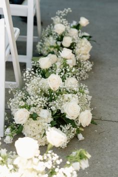 white flowers and baby's breath are lined up along the aisle