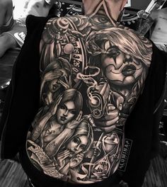 the back of a man's body covered in black and white tattoos, with images of people on it