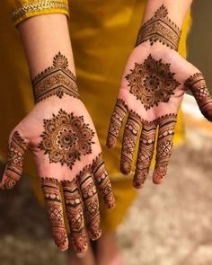 two hands with henna designs on them