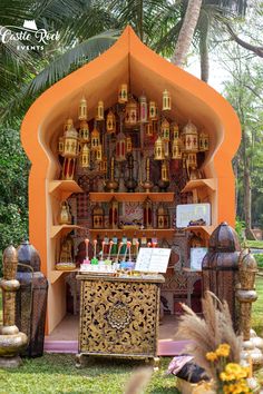 an outdoor shrine with lots of items on the shelves and decorations in front of it