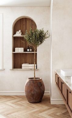 a potted plant sitting on top of a wooden table next to a bathroom sink