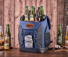 a cooler bag filled with beer bottles on top of a wooden table