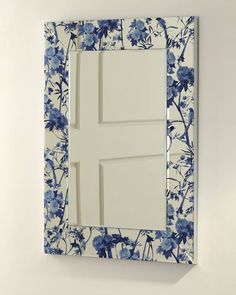 a blue and white mirror hanging on the wall