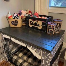 a dog crate sitting on top of a wooden table filled with toys and other items