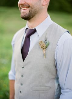 a man wearing a vest and tie with a boutonniere on his lapel