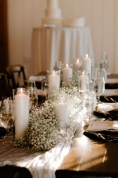 the table is set with candles, flowers and wine glasses for an elegant wedding reception