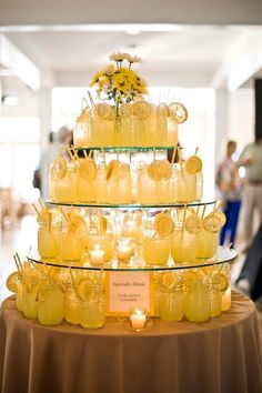 there is a cake made out of jars with candles in them and flowers on top