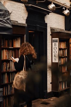 a woman is standing in front of a book store