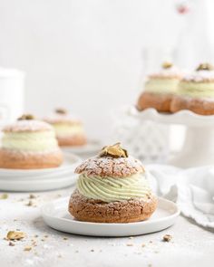 two desserts are sitting on white plates and one is topped with green frosting