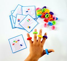 a child's hand with several different colored plastic letters