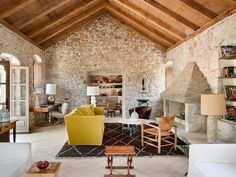 a living room filled with furniture and stone walls