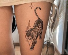 a woman's thigh with a tattoo of a leopard on it