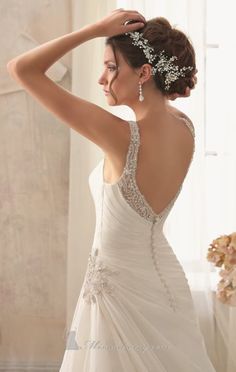 the back of a wedding dress with beading and pearls on it, in front of a