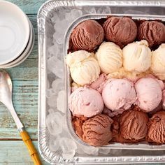 an ice cream container filled with different types of ice creams next to a spoon