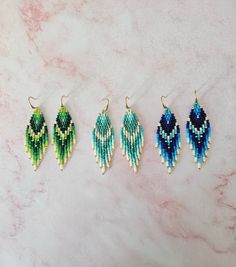 four pairs of beaded earrings on a marble surface