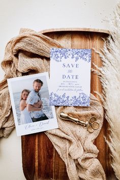 a couple's save the date card and wedding hair comb on a wooden tray