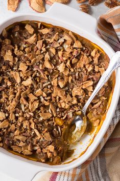 a casserole dish with nuts and caramel sauce in it on a plaid cloth