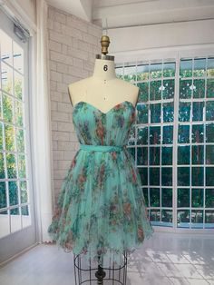 This handmade strapless dress in aqua green features a delicate floral pattern, perfect for summer parties and casual events. The bodice has a sweetheart neckline, offering a flattering silhouette. The layered tulle skirt flows elegantly and adds a touch of whimsy to the dress. A charming bow at the back completes the look, making it both playful and sophisticated. Ideal for weddings, summer festivals, or any special occasion where you want to stand out with a unique, handcrafted piece. *Size: 6 Short Dress With Bow, Floral Short Dress, Green Summer Dress, Green Summer Dresses, Layered Tulle Skirt, Summer Festivals, Floral Dresses Short, Floral Short, Summer Parties