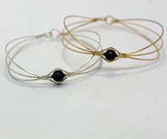 A sweet design of three strands of 14kt gold filled wire featuring a single 6mm genuine garnet bead flanked by two small 14kt gold filled beads. The garnet bead is a very deep dark red, almost black (unless you hold it up to the light or next to something that's actually black!) This stylish, well-fitting bangle will go with most everything in your closet, and is sure to get noticed every time you wear it. So delicate and feminine! The sturdy built-in hook and eye clasp is easy to get on and off Dainty Adjustable Wire Wrapped Beaded Bracelets, Adjustable Sterling Silver Wire Wrapped Bracelets, Dainty Adjustable Wire Wrapped Bracelets, Elegant Hand Wrapped Bangle Wrap Bracelet, Elegant Hand Wrapped Wrap Bracelet Bangle, Elegant Adjustable Wire Wrapped Bracelets, Elegant Wire Wrapped Bracelets As Gifts, Elegant Wire Wrapped Bracelet Jewelry, Gold Wire Wrapped Wrap Bracelet As A Gift