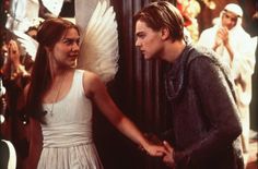 the young man and woman are standing next to each other in front of an angel